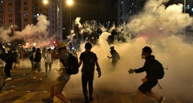 Manifestantes se congregan en medio de gases lacrimógenos, afuera de una estación de policía en el distrito Wong Tai Sin de Hong Kong, luego de que activistas arrestados fueran llevados a la comisaria. (Foto: AFP)