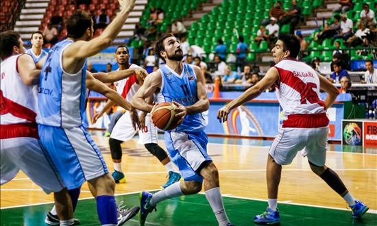 El jugador Martin Osimany (c) de Uruguay se dirige a la cesta ante Luis Saldaña (d) de Perú, durante un juego del Torneo Sudamericano de Baloncesto, en Margarita (Venezuela). EFE
