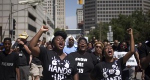 Activists raise their hands as they demand justice for the killing of Michael Brown while marching to the Thomas F. Eagleton United States Courthouse from City Hall in downtown St. Louis, Missouri
