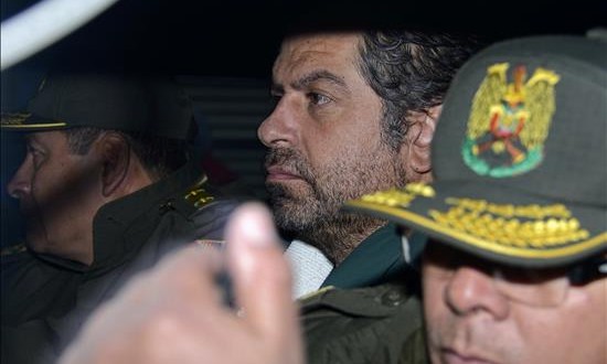 Policías bolivianos escoltan al empresario peruano Martín Belaunde Lossio (c) en el acto de entrega a las autoridades peruanas en el puente internacional de Desaguadero, localidad fronteriza entre Bolivia y Perú.