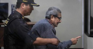 El fundador de Sendero Luminoso, Abimael Guzmán (d), es custodiado por un policía durante una audiencia en la Base Naval del Callao en Perú.