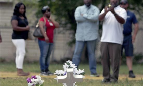 Un grupo de personas se reúne en el sitio donde Walter L. Scott, de 50 años, recibió disparos de un policía blanco en North Charleston (EE.UU.).