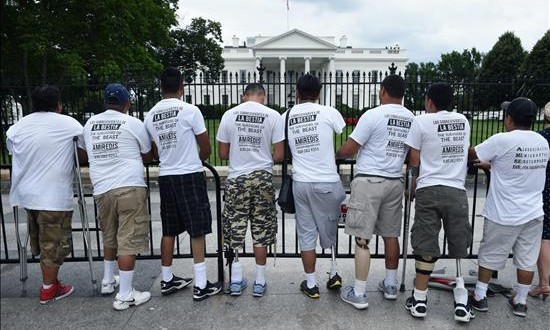 Unos grupo de inmigrantes indocumentados hondureños mutilados por el tren de mercancías conocido como "La Bestia" se apostan hoy, miércoles 17 de junio 2015, frente a la Casa Blanca en Washington, DC, donde están de visita para exigir una reunión al presidente, Barack Obama, y para denunciar la pesadilla de un viaje que se cobró sus piernas, cortó sus manos y sesgó sus esperanzas. La llegada del grupo de inmigrantes coincidió con la visita a la capital federal del presidente de Honduras, Juan Orlando Hernández, para reunirse con el secretario general de la Organización de Estados Americanos (OEA), Luis Almagro, y el vicepresidente, Joe Biden, con el que preveía abordar temas de violencia y migración en Centro América.