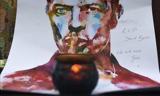 Artistas y políticos lamentan la muerte de Bowie, un "héroe" de la música
Una vela encendida frente a una acuarela del cantante británico David Bowie en Brixton, Londres (Reino Unido), el 11 de enero de 2016.