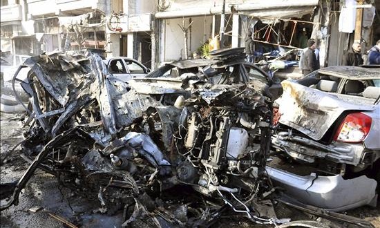 EI reivindica la autoría del atentado que ha causado 24 muertos en la ciudad siria de Homs
Varios vehículos dañados en el lugar del atentado suicida perpetrado hoy en el barrio de Al Zahrá, de mayoría alauí, en la ciudad central siria de Homs.