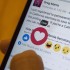In this Thursday, Feb. 18, 2016 photo taken in New York, Julie Zhuo, product design director at Facebook, demonstrates the new emoji-like stickers customers will be able to press in addition to the like button. Facebook's Like button is getting some company, as the company rolls out alternatives worldwide after testing in a few countries. (AP Photo/Mary Altaffer)