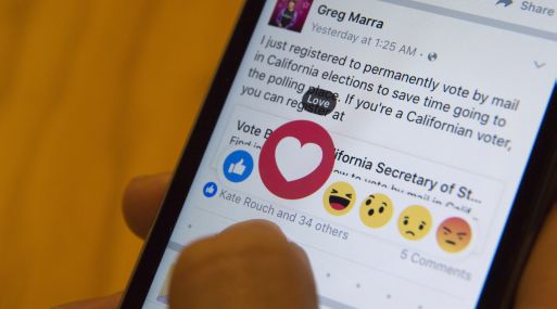 In this Thursday, Feb. 18, 2016 photo taken in New York, Julie Zhuo, product design director at Facebook, demonstrates the new emoji-like stickers customers will be able to press in addition to the like button. Facebook's Like button is getting some company, as the company rolls out alternatives worldwide after testing in a few countries. (AP Photo/Mary Altaffer)