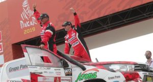Los peruanos Luis Alayza (c) e Ive Bromberg (i) saludan en el podio de partida del rally Dakar 2019 en la Costa Verde en Lima (Perú). EFE/Archivo