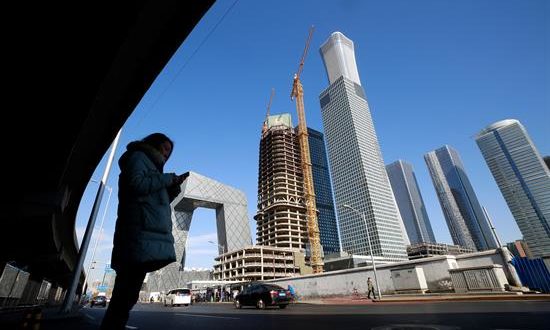Una mujer espera para cruzar una calle en Pekín (China). EFE/Archivo