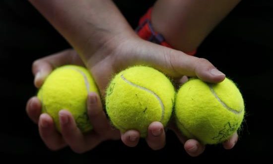 Una recogepelotas sujeta tres bolas durante un partido. EFE/Archivo