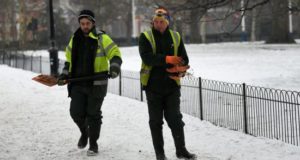 Empleados esparcen grava por un camino del St James's Park en Londres, Reino Unido, tras una nevada. EFE/Archivo