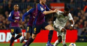 El delantero brasileño del Real Madrid Vinicius Junior (d) se escapa del croata Ivan Rakitic, del FC Barcelona, durante el partido de ida de las semifinales de la Copa del Rey que FC Barcelona y Real Madrid jugaron en el Camp Nou, en Barcelona. EFE