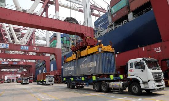 En la imagen, un camión mientras descarga un contenedor en el puerto de Qingdao (China). EFE/Archivo