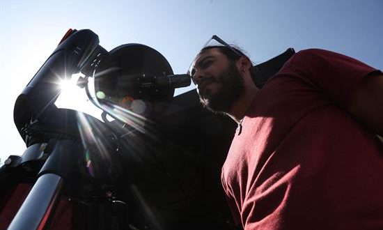 Fotografía fechada el 29 de enero de 2019, que muestra a un hombre mientras mira por un telescopio, en La Serena (Chile). EFE