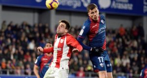 El centrocampista del Huesca Cristian Rivera (d) y el centrocampista del Athletic Beñat Etxebarría (i) luchan por el balón durante el partido de la vigésimo cuarta jornada de Liga que disputan en el estadio Alcoraz de Huesca. EFE