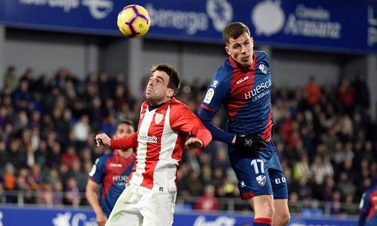 El centrocampista del Huesca Cristian Rivera (d) y el centrocampista del Athletic Beñat Etxebarría (i) luchan por el balón durante el partido de la vigésimo cuarta jornada de Liga que disputan en el estadio Alcoraz de Huesca. EFE