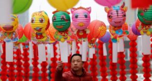 Un hombre lee poemas colgados de farolillos de papel, este martes, durante la celebración del Festival de los Faroles en Yufa, en el distrito rural de Daxing en Pekín (China). El Festival de los Faroles marca el fin de las festividades del Año Nuevo Lunar. EFE