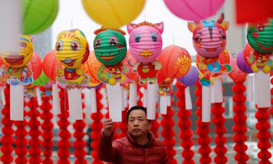 Un hombre lee poemas colgados de farolillos de papel, este martes, durante la celebración del Festival de los Faroles en Yufa, en el distrito rural de Daxing en Pekín (China). El Festival de los Faroles marca el fin de las festividades del Año Nuevo Lunar. EFE