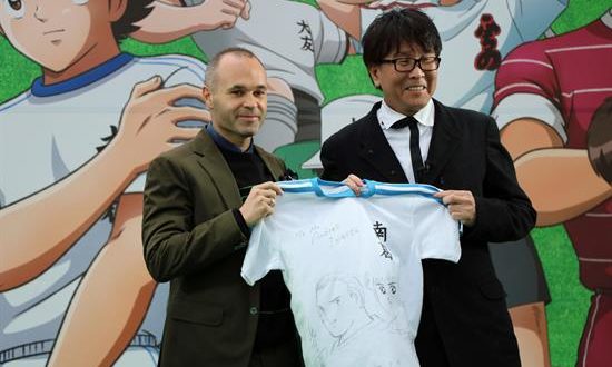 El futbolista español Andrés Iniesta (i), recibe una camiseta personalizada de manos del autor de "Captain Tsubasa" ("Oliver y Benji" en España, "Supercampeones" en Hispanoamérica), Yoichi Takahashi (d), dedicada y con un dibujo suyo junto al protagonista de la serie, Oliver Atom, durante su asistencia este lunes a la presentación de la redecoración de la estación Yotsugi de Tokio, que ha sido cubierta con imágenes de los personajes de la popular serie sobre fútbol. EFE
