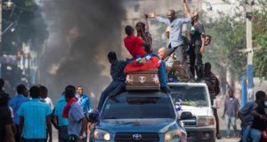 Haitianos acompañaban cuatro féretros rumbo al cementerio mientras se desata una protesta este lunes, en Puerto Príncipe (Haití). EFE