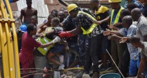 Operarios rescatan a un niño entre los escombros tras derrumbarse un edificio este miércoles en Lagos, Nigeria. EFE