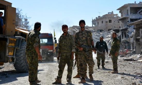 Combatientes de las Fuerzas de Siria Democrática (FSD) operan cerca de edificios dañados en el centro de Al Raqa (Siria). EFE/Archivo