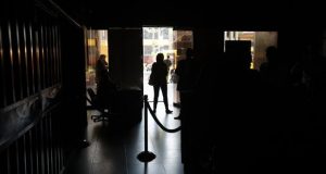 Un grupo de personas permanece en medio de la oscuridad al interior del edificio de la Asamblea Nacional este lunes en Caracas (Venezuela). EFE