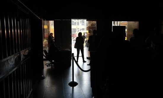Un grupo de personas permanece en medio de la oscuridad al interior del edificio de la Asamblea Nacional este lunes en Caracas (Venezuela). EFE