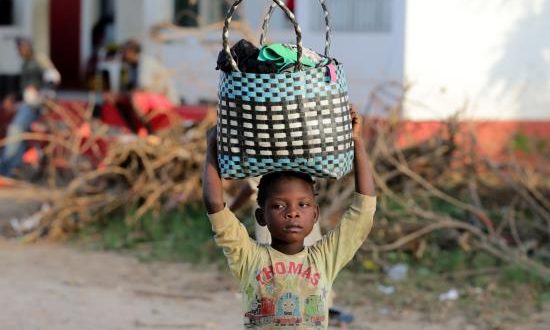 Una niña transporta ropa llegada en un barco en el río Buzi en Sofala (Mozambique), este miércoles. EFE