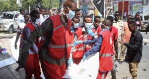 Médicos somalíes trasladan el cadáver de una víctima tras la explosión de un coche bomba, este jueves, frente a un popular restaurante en el centro de Mogadiscio. EFE