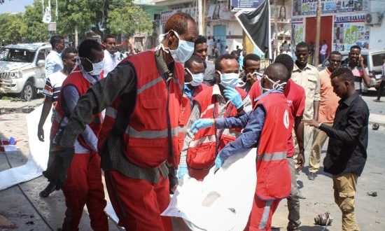 Médicos somalíes trasladan el cadáver de una víctima tras la explosión de un coche bomba, este jueves, frente a un popular restaurante en el centro de Mogadiscio. EFE