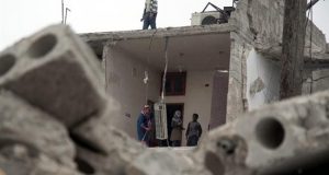 Una familia siria limpia su casa destruida después del impacto de un misil en Alepo (Siria). EFE/Archivo