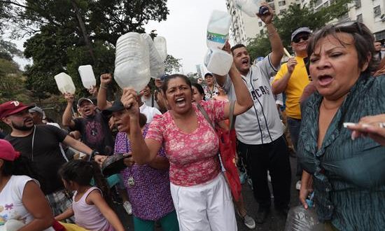 Vecinos protestan por la falta de electricidad y de agua este domingo, en Caracas (Venezuela). El país ha vivido cortes de energía durante siete días consecutivos, mientras que en algunos sectores cercanos a la capital los manifestantes reportaron que llevan más de una semana sin bombeo de agua. EFE