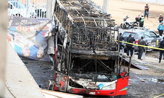 Fotografía cedida por la Agencia Andina que muestra un autobús incendiado este lunes, en el interior del terminal terrestre informal de Fiori, en la zona norte de Lima (Perú). EFE/ Agencia Andina