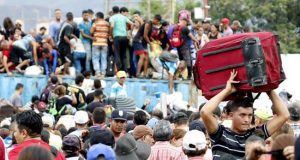 Cientos de personas se suben a los contenedores que obstaculizan el Puente Internacional Simón Bolívar, este martes, en Cúcuta (Colombia). EFE
