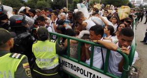 Cientos de personas cruzan el Puente Internacional Simón Bolívar a pesar de los contenedores que lo bloquean, este martes, en Cúcuta (Colombia). EFE