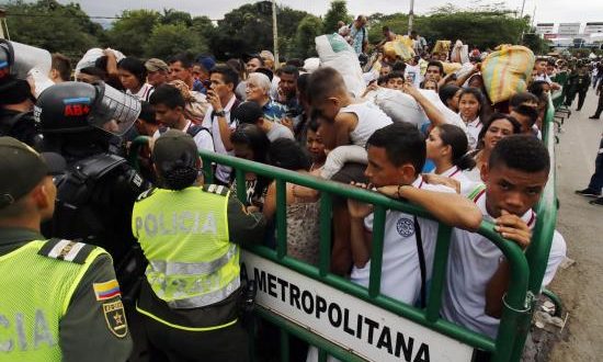 Cientos de personas cruzan el Puente Internacional Simón Bolívar a pesar de los contenedores que lo bloquean, este martes, en Cúcuta (Colombia). EFE