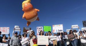 El globo "Bebé Trump" flota sobre un grupo de manifestantes este viernes en Calexico, California, durante la visita del presidente, Donald Trump, a la frontera con México. EFE