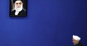 El presidente iraní, Hasan Rohaní (dcha), pasa bajo un retrato del líder supremo, Ali Jamenei, antes de dar una rueda de prensa en Teherán (Irán). EFE/Archivo