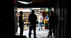 Comerciantes atienden sus negocios a oscuras tras un corte de energía en Caracas (Venezuela). EFE/Archivo