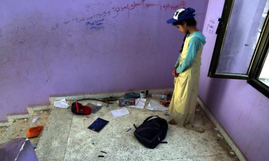 Una niña yemení busca su mochila en una escuela evacuada por un bombardeo en Saná (Yemen), este lunes. EFE