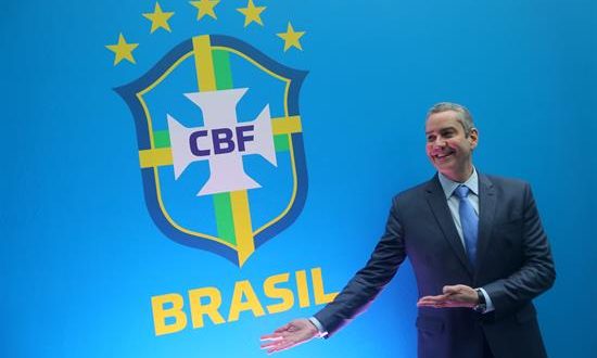 El nuevo presidente de la Confederación Brasileña de Fútbol (CBF), Rogério Caboclo, posa junto al escudo de la CBF durante un evento este martes, en Río de Janeiro (Brasil). EFE