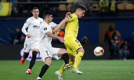 El centrocampista argentino del Villarreal, Santiago Cáseres (d), intenta controlar el balón ante el jugador portugués del Valencia, Gonçalo Guedes, durante el encuentro correspondiente a la ida de los cuartos de final de la Liga Europa que disputaron en el estadio de la Cerámica, en la localidad castellonense. EFE