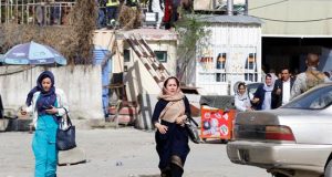 Empleados del ministerio de Información afgano huyen del lugar del ataque, hoy en Kabul. EFE