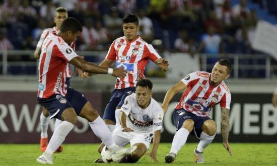 Rafael Pérez (i) de Junior disputa un balón con Adolfo Gaich (c) de San Lorenzo este jueves en un partido del grupo F de la Copa Libertadores entre Atlético Junior y San Lorenzo en el estadio Metropoliano en Barranquilla (Colombia). EFE