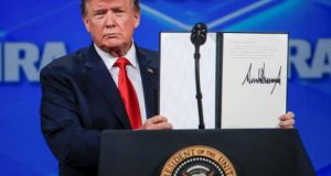 El presidente estadounidense, Donald Trump, muestra una resolución firmada tras su discurso ante el encuentro anual de la Asociación Nacional del Rifle (NRA) en Indianapolis (Estados Unidos), este viernes. EFE