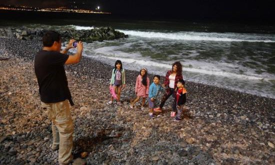 Visitantes se toman fotografías, en la playa Pampilla de Lima (Perú). EFE/Archivo