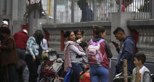 Los migrantes venezolanos esperan en la embajada de su país un autobús que los transportará al aeropuerto de Lima, Perú. Foto de archivo.