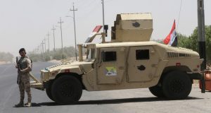 Un soldado iraquí junto a un vehículo militar, Basora, Irak, 19 de junio de 2019.