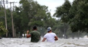 Dos hombres caminan por una calle inundada tras el paso del huracán Barry en Mandeville, Louisiana, EE.UU., el sábado,13 de julio de 2019.